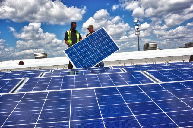 Brightergy installer installing Sunpower panels on the solar array atop Rockhurst High School