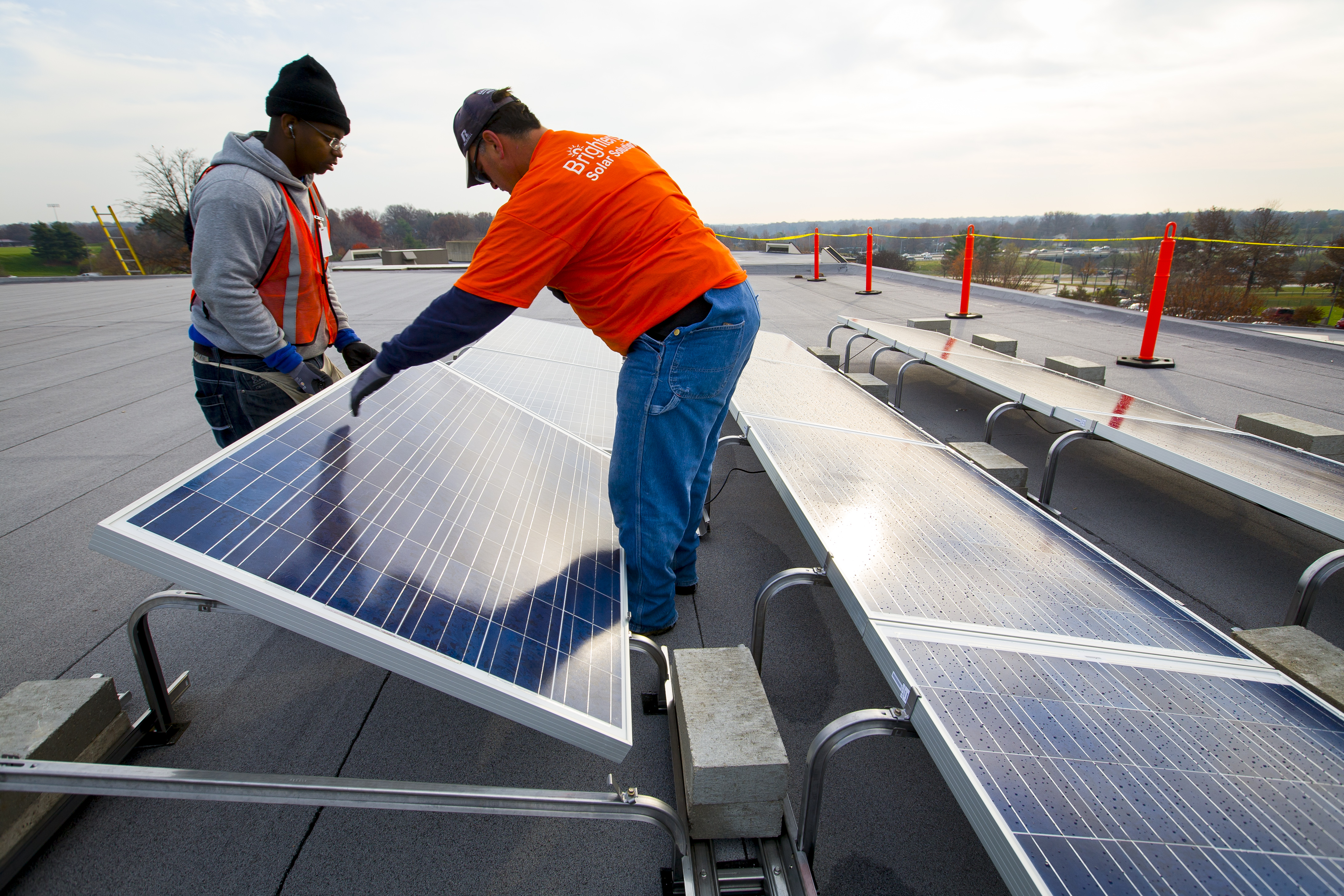 Solar power installers at work installing solar panels at Parkway Northeast Middle School.