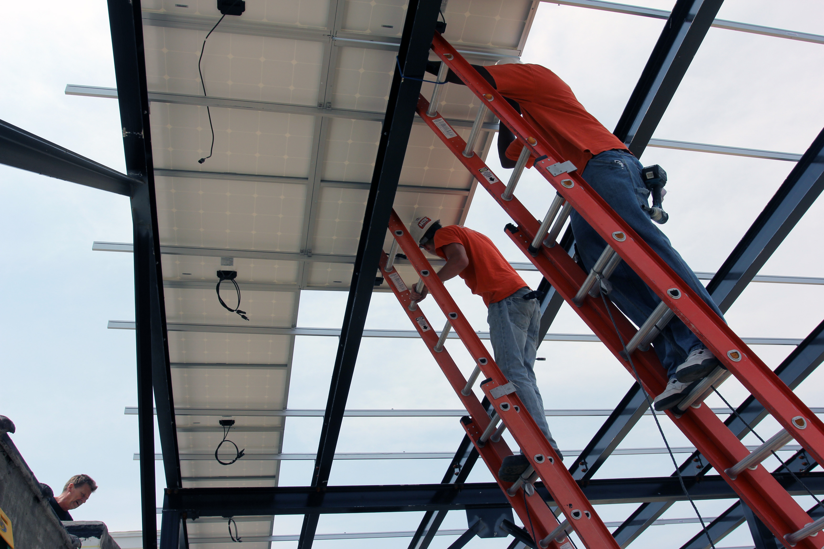 Paul and Terry at work securing solar panels to the canopy's racking. 