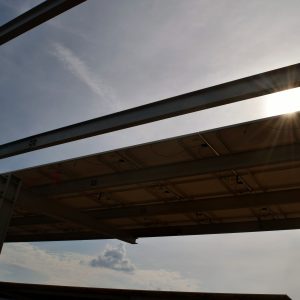 sun shining through solar panels at UMass Amherst