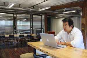 Bruce Wang at his laptop in Brightergy office